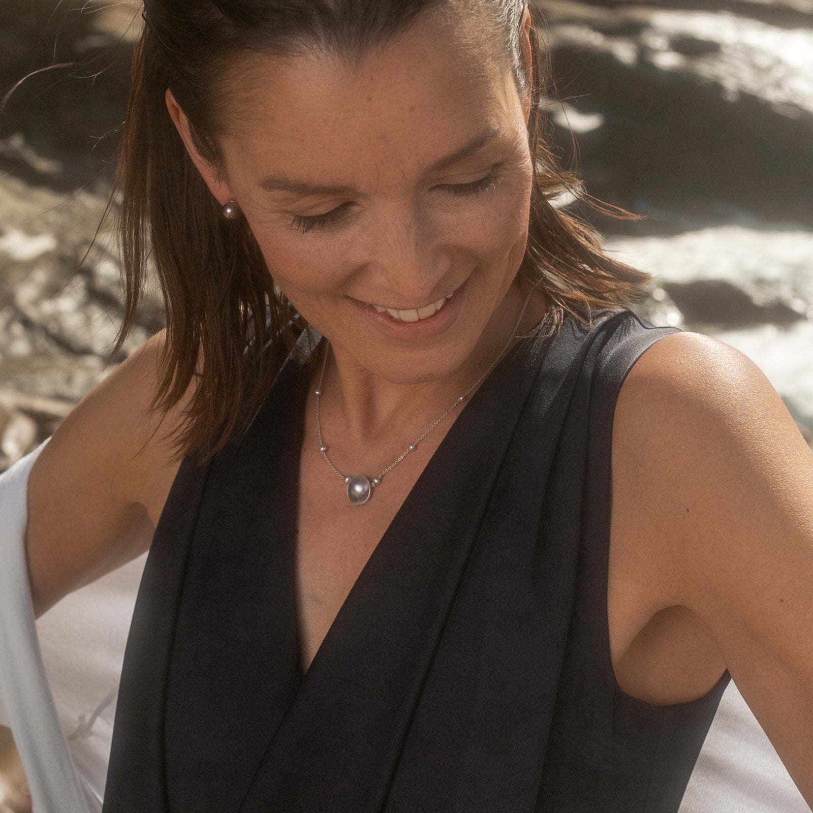 A necklace featuring a single grey Butterfly Oyster Mabe pearl on a white gold chain, with additional freshwater pearls attached.
